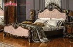 Sudut samping dekorasi set tempat tidur jati seri Montreal dengan finishing warna dark walnut kombinasi emas dan sprei abu-abu produk Hasan Jati Furniture.