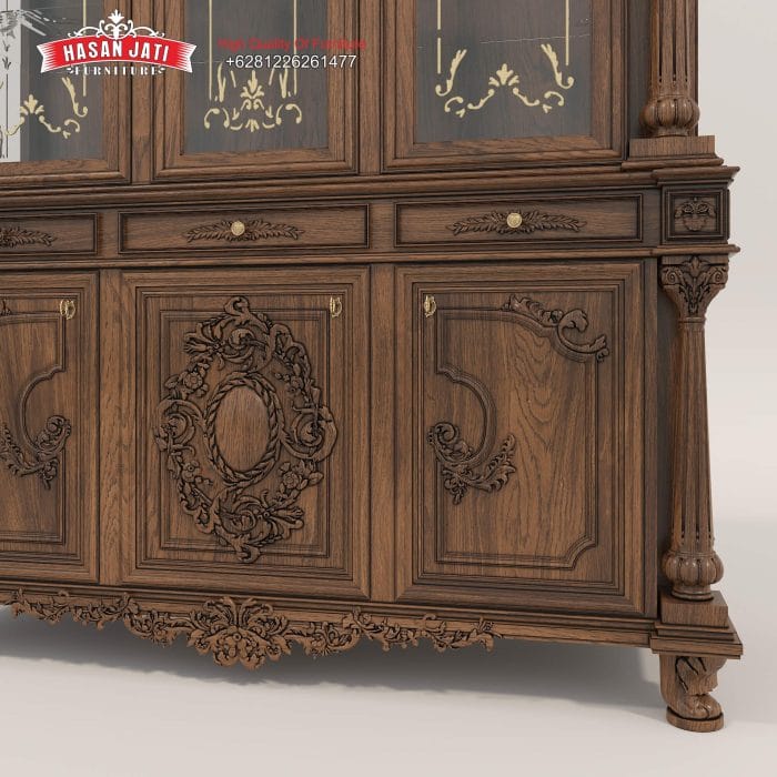 Detail susunan 3 laci tengah, pintu kayu dengan ukiran medallion untaian bunga, serta kaki penopang pada bodi bawah lemari jati mewah klasik grafir emas.