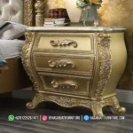 Meja nakas lampu tidur dengan profil laci cembung dan kaki lengkung berukir warna emas dari set kamar mewah seri Eastern produk Hasan Jati Furniture.