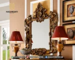 Detail mahkota ukiran rimbun klasik pada pigura bingkai cermin dinding besar seri Seraphine warna emas antik produk jepara dengan watermark Hasan Jati Furniture.