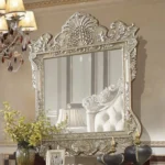 Bingkai cermin dinding gantung ukir mewah tipe Vatican warna champagne silver memantulkan interior sandaran kasur produk Hasan Jati Furniture.