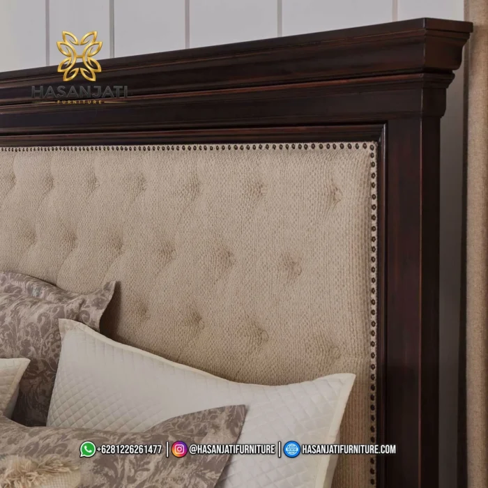 Close up sandaran kepala atau headboard tempat tidur Brynhurst memperlihatkan detail empuk jok kain beige motif kancing tanam dan list paku payung kuningan produk Hasan Jati Furniture.