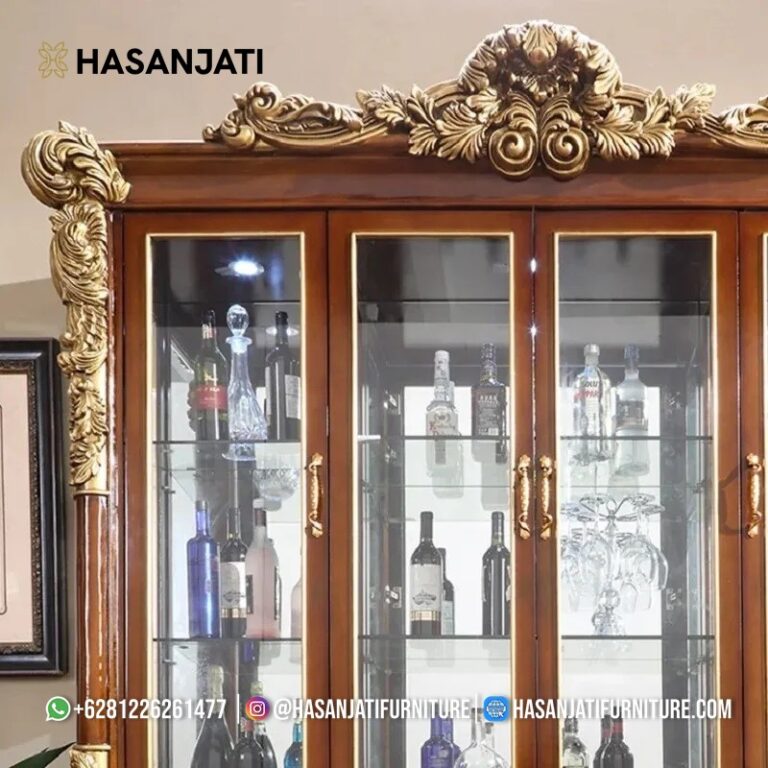 Close up detail seni pahat tangan manual pada mahkota kerang Baroque dan jajaran pintu kaca atas lemari hias Piazza jepara.