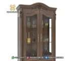 Detail dekorasi ukiran mahkota atas dan pilar samping daun pintu kaca lemari hias jati Cordelia produk Hasan Jati Furniture.