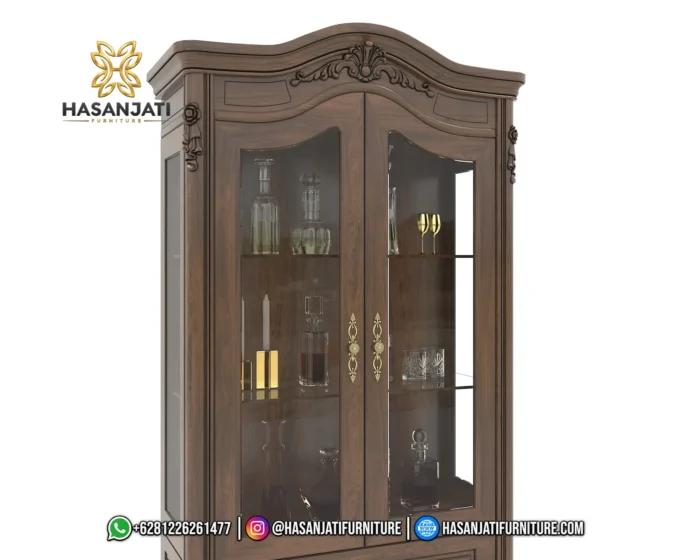 Detail dekorasi ukiran mahkota atas dan pilar samping daun pintu kaca lemari hias jati Cordelia produk Hasan Jati Furniture.