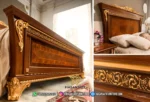 Detail ukiran emas gold leaf dan profil serat kayu jati eksotis pada bagian footboard dan headboard dipan seri Aida produk Hasan Jati Furniture.