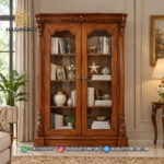 Penempatan kabinet display mewah seri Gloucester 2 pintu kaca di samping jendela ruang keluarga dalam interior hunian klasik neoklasik.