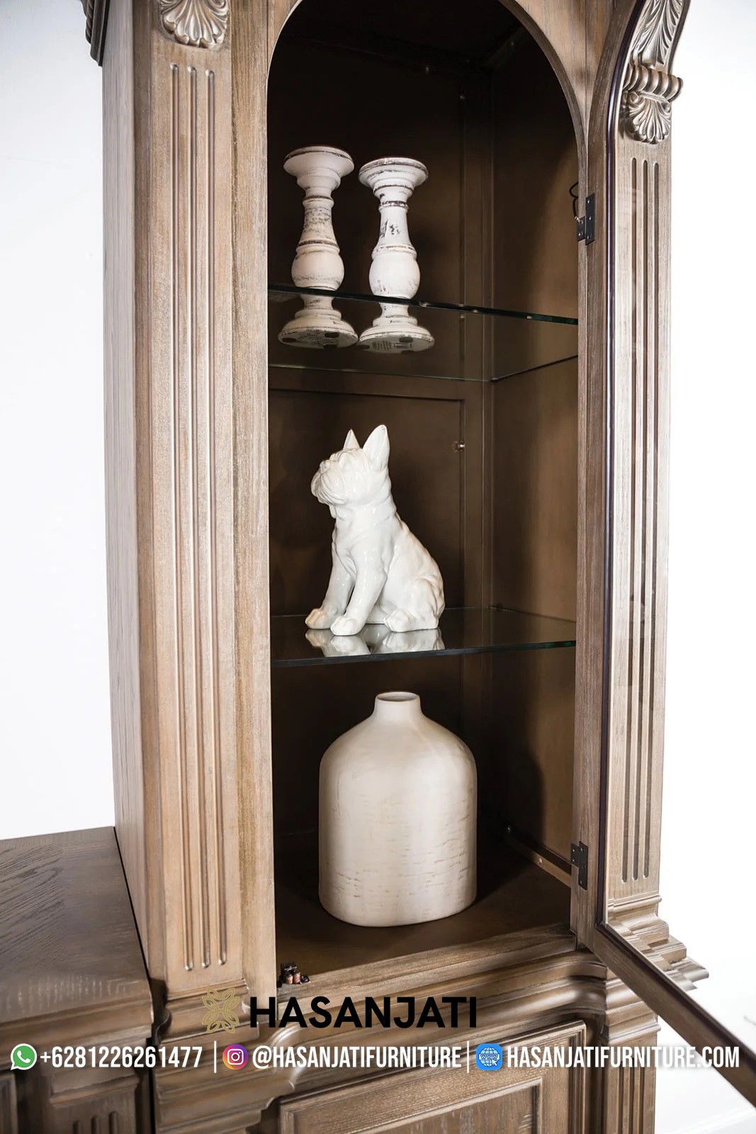 Interior lemari kaca pajangan set bufet TV jati, memperlihatkan rak kaca dan pintu melengkung yang elegan untuk memajang dekorasi.
