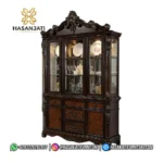 Tampilan penuh lemari hias jati mewah seri Manzanita 3 pintu kaca warna cokelat gelap berlatar putih polos produk Hasan Jati Furniture.