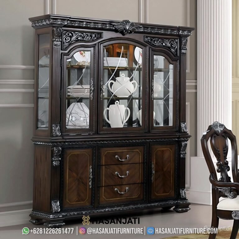 Tampilan penuh lemari hias jati mewah seri Promenade 3 pintu kaca warna cokelat gelap kombinasi ukiran perak di dalam ruang keluarga produk Hasan Jati Furniture.