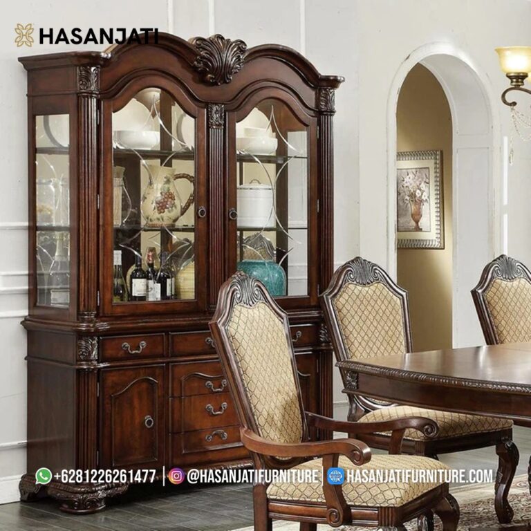 Penempatan lemari hias mewah seri Chateau De Ville di belakang set meja makan kayu dan kursi berlapis kain motif batik emas.