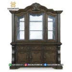 Tampilan penuh tampak depan lemari pajangan kristal seri Maylee dari kayu jati memperlihatkan susunan 3 pintu kaca berteralis silang dan buffet bawah.