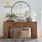 Meja konsol jati solid seri Block Rustic dengan hiasan vas bunga putih besar dan cermin bulat hitam tampak depan berlatar dinding putih panel