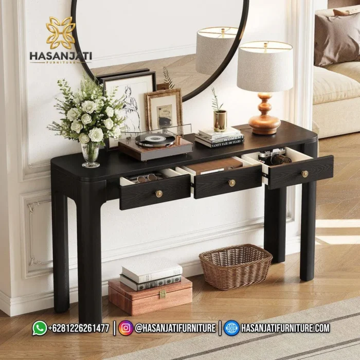 Meja konsol jati warna hitam seri Solstice 3 laci terbuka dihiasi vas bunga putih berlatar cermin bulat besar.