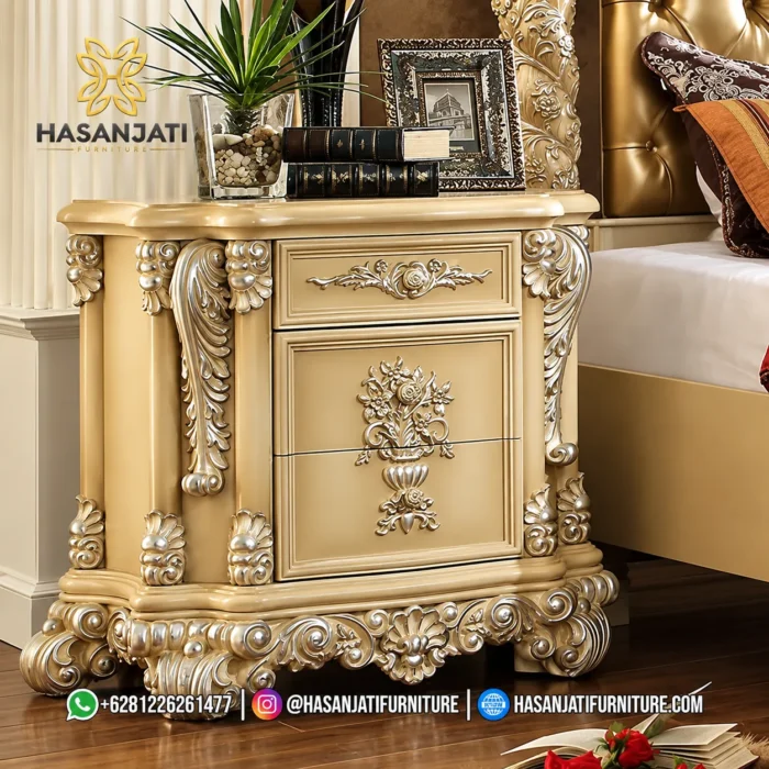 Tampilan close up nakas lampu tidur laci dari set kamar tidur mewah seri Rowena cat duco dengan ornamen ukiran bunga berlapis perak produk Hasan Jati Furniture.