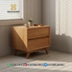 Tampilan dekat meja nakas lampu tidur minimalis dua laci warna kayu natural dengan sorotan cahaya matahari dari jendela produk Hasan Jati Furniture.