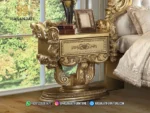 Tampilan close up meja nakas lampu tidur dengan model kaki cawan silinder berukir warna emas dari set kamar mewah seri Bernadette produk Hasan Jati Furniture.
