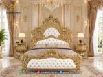 Tampak depan ranjang ukir mewah seri Bernadette Palace Gold dengan sandaran kulit putih kancing kristal dan sepasang nakas produk Hasan Jati Furniture.